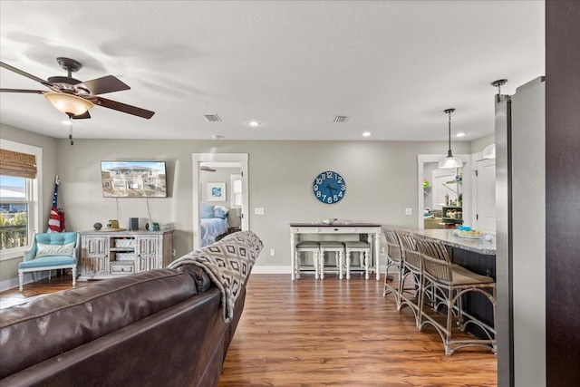 living room with wood-type flooring and ceiling fan