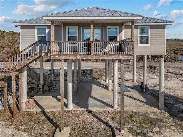 rear view of house with a carport and a patio