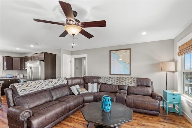 living room with ceiling fan and light wood-type flooring