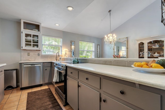 6509 Alan A Dale Trl, Tallahassee, FL 32309 - kitchen featuring stainless steel appliances, light countertops, light tile patterned floors, vaulted ceiling, and tasteful backsplash