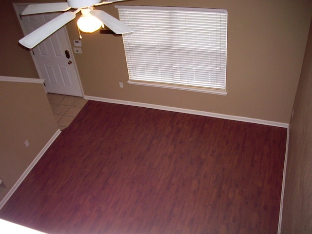 spare room featuring baseboards, a ceiling fan, and wood finished floors