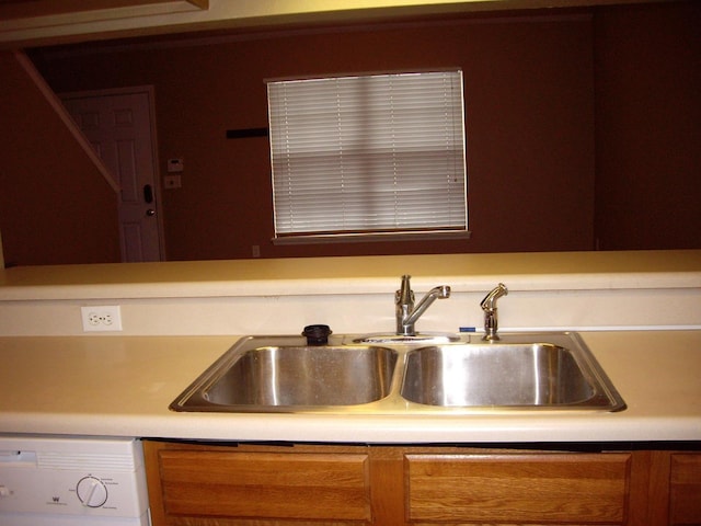 kitchen featuring a sink, white dishwasher, and light countertops