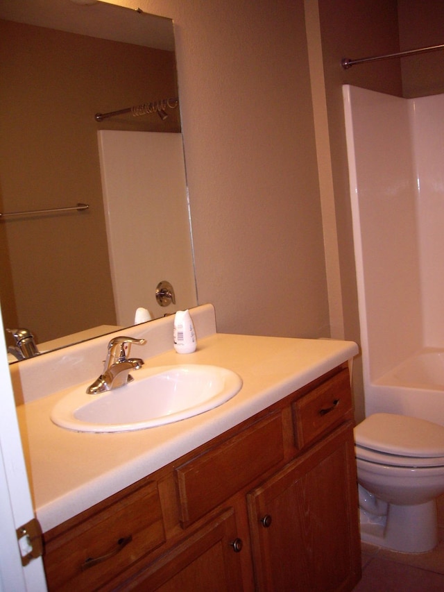 bathroom with vanity, toilet, and  shower combination