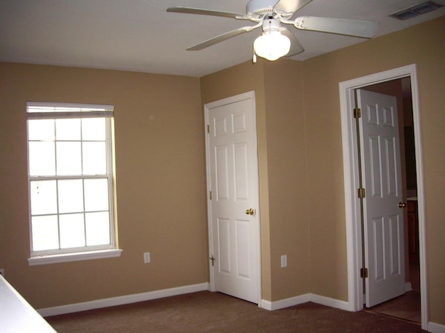 unfurnished bedroom featuring carpet flooring, multiple windows, and baseboards