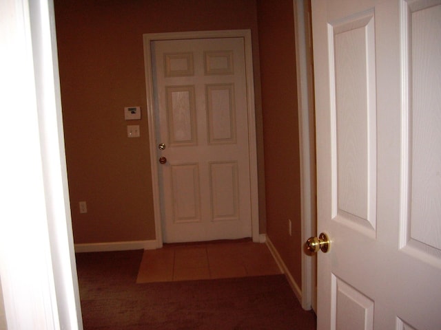 corridor featuring baseboards and tile patterned floors