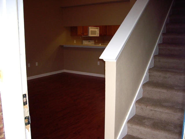 stairs featuring wood finished floors and baseboards