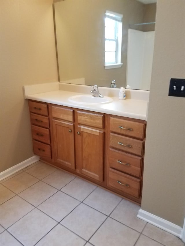 bathroom with vanity, tile patterned floors, and baseboards