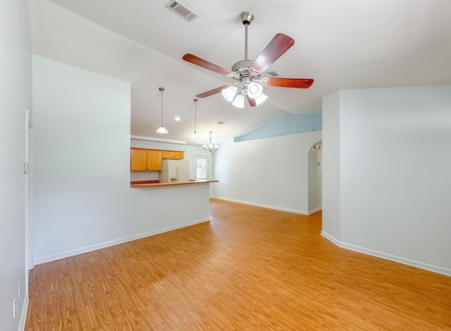 unfurnished living room featuring visible vents, light wood-style floors, ceiling fan with notable chandelier, baseboards, and vaulted ceiling