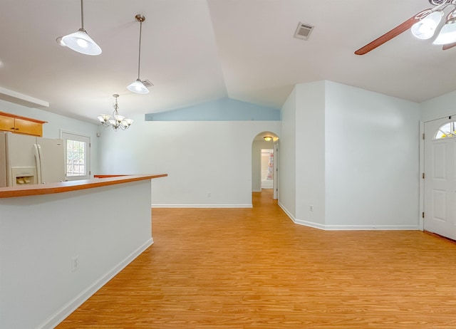 unfurnished living room with visible vents, lofted ceiling, light wood-type flooring, arched walkways, and ceiling fan with notable chandelier