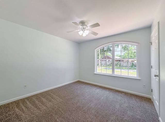 carpeted empty room featuring baseboards and a ceiling fan
