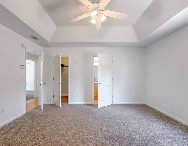 unfurnished bedroom with carpet flooring, baseboards, visible vents, and a spacious closet