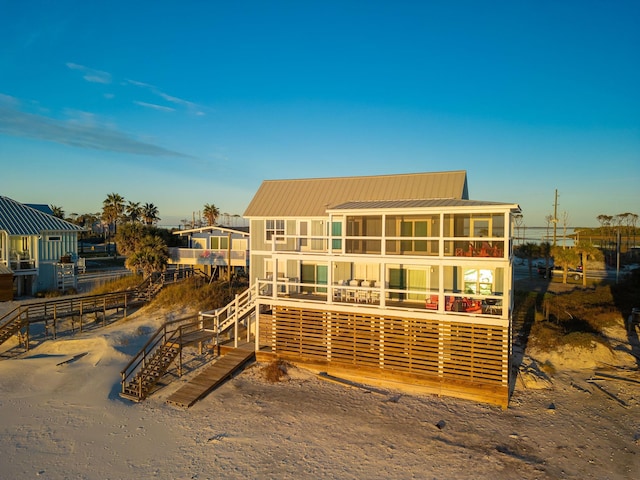 rear view of house featuring a balcony and a sunroom