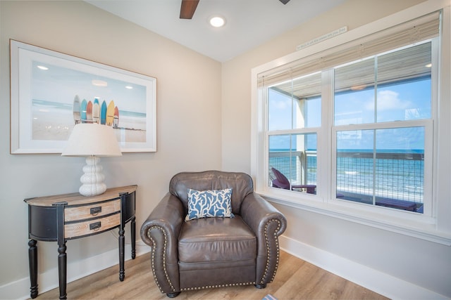 sitting room featuring a water view, ceiling fan, and light hardwood / wood-style floors