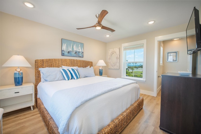 bedroom with ceiling fan and light hardwood / wood-style flooring