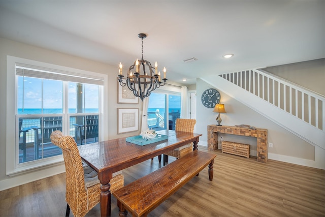 dining room with wood-type flooring, plenty of natural light, and a water view