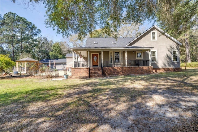 view of front of property featuring covered porch, a gazebo, a front lawn, and stucco siding