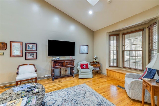 living area featuring vaulted ceiling, recessed lighting, wood finished floors, and baseboards