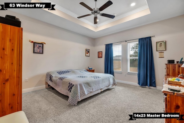 carpeted bedroom featuring a tray ceiling, ceiling fan, and ornamental molding