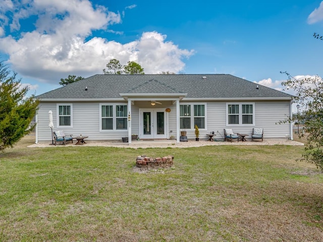 back of property featuring french doors, an outdoor fire pit, a patio, and a lawn