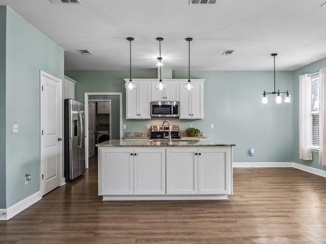 kitchen featuring white cabinetry, a kitchen island with sink, stainless steel appliances, light stone countertops, and decorative light fixtures