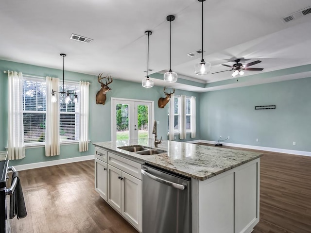 kitchen featuring pendant lighting, sink, white cabinets, stainless steel dishwasher, and light stone counters