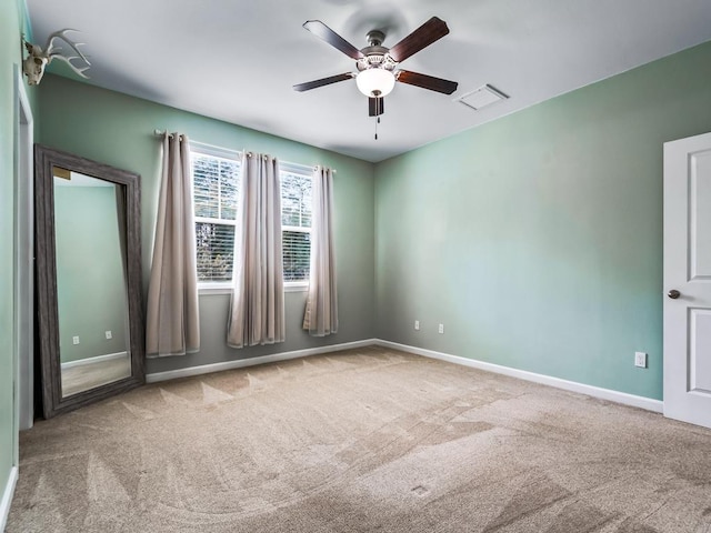 carpeted spare room featuring ceiling fan