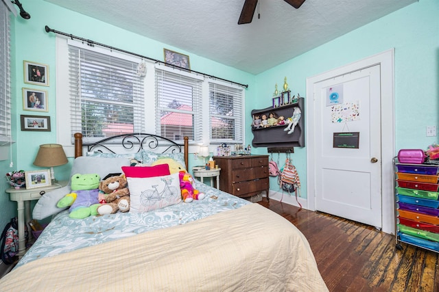 bedroom featuring ceiling fan, dark hardwood / wood-style flooring, and a textured ceiling