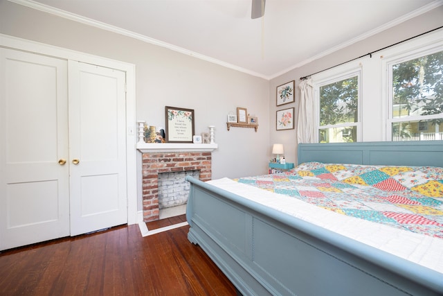 bedroom featuring a fireplace, ornamental molding, dark hardwood / wood-style floors, and ceiling fan