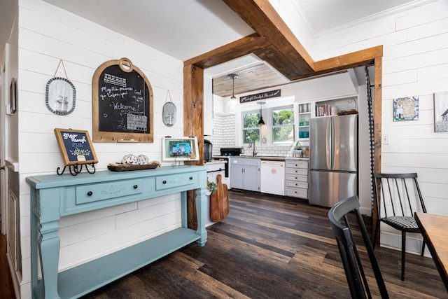 kitchen featuring wooden walls, stainless steel refrigerator, decorative light fixtures, dark hardwood / wood-style flooring, and white dishwasher