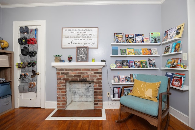 living area with crown molding, a fireplace, and dark hardwood / wood-style floors