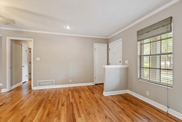 empty room with crown molding and light wood-type flooring