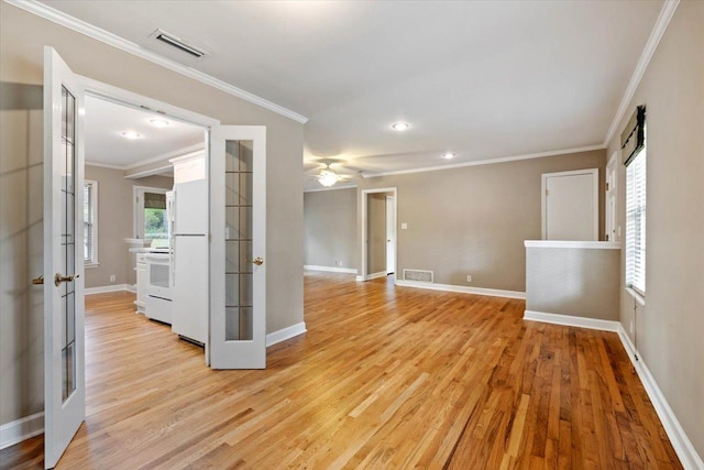 spare room featuring french doors, crown molding, and light hardwood / wood-style flooring