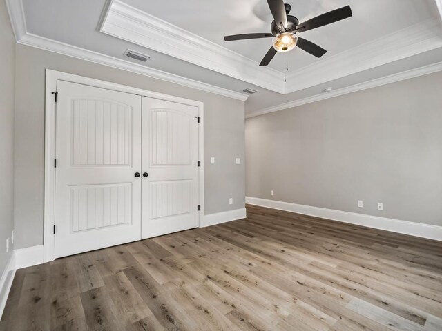 70 Beeler Rd, Crawfordville, FL 32327 - unfurnished bedroom featuring wood finished floors, ornamental molding, a closet, a tray ceiling, and a ceiling fan