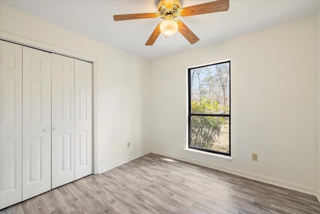 unfurnished bedroom featuring light wood-type flooring, a closet, and ceiling fan