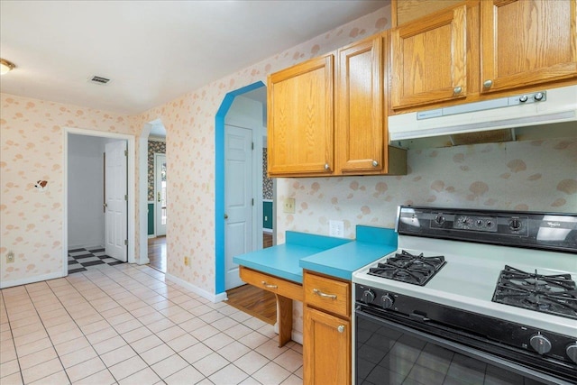 kitchen with light tile patterned floors and range with gas stovetop