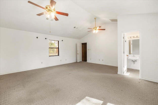 carpeted empty room with ceiling fan and high vaulted ceiling