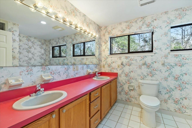 bathroom featuring tile patterned flooring, vanity, toilet, and a healthy amount of sunlight