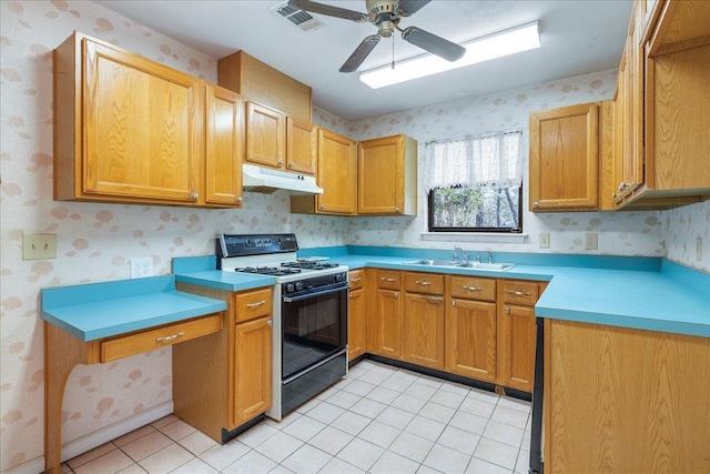 kitchen featuring ceiling fan, light tile patterned floors, sink, and gas range