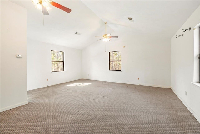 empty room featuring vaulted ceiling, ceiling fan, and light colored carpet