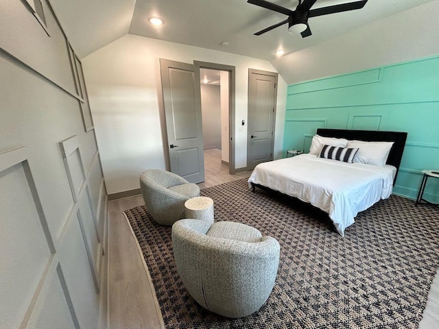 bedroom with baseboards, a ceiling fan, light wood finished floors, and vaulted ceiling