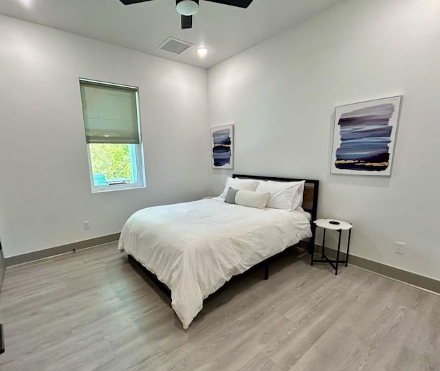 bedroom featuring light wood-style flooring, visible vents, baseboards, and ceiling fan