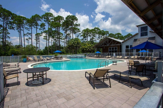 community pool featuring fence and a patio