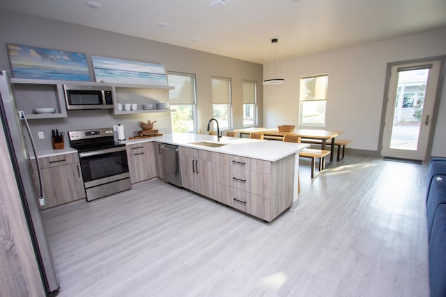 kitchen featuring stainless steel appliances, hanging light fixtures, light countertops, and open shelves