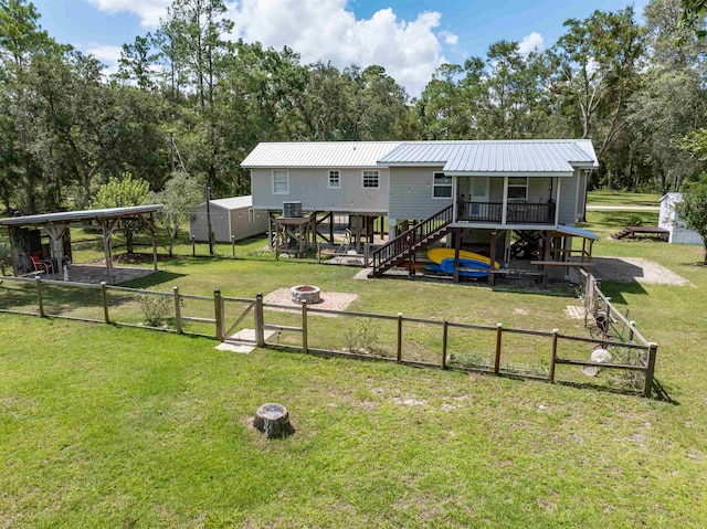 back of property featuring a wooden deck and a yard