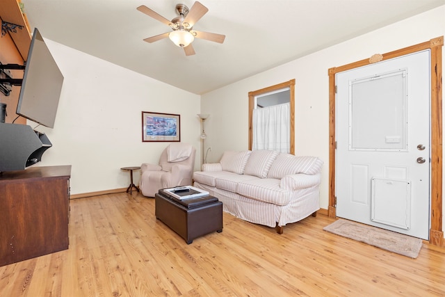 living room with ceiling fan, lofted ceiling, and light hardwood / wood-style floors