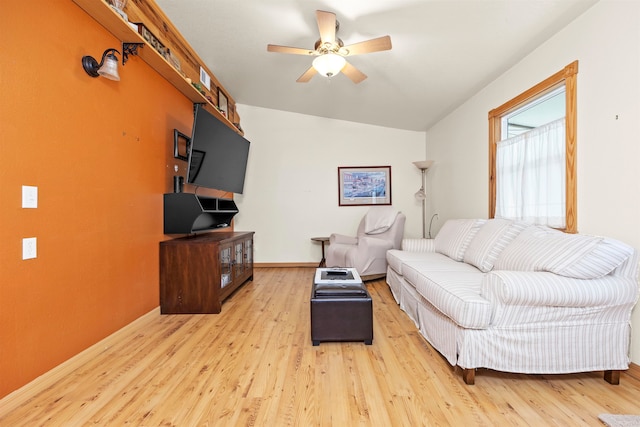 living room with ceiling fan, light hardwood / wood-style flooring, and vaulted ceiling