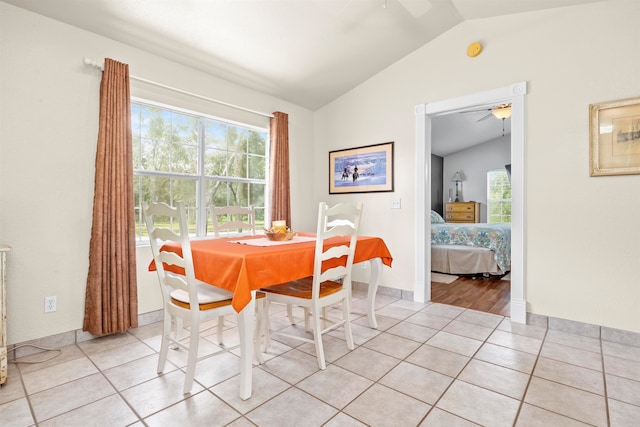 dining room with light tile patterned flooring, ceiling fan, a healthy amount of sunlight, and vaulted ceiling