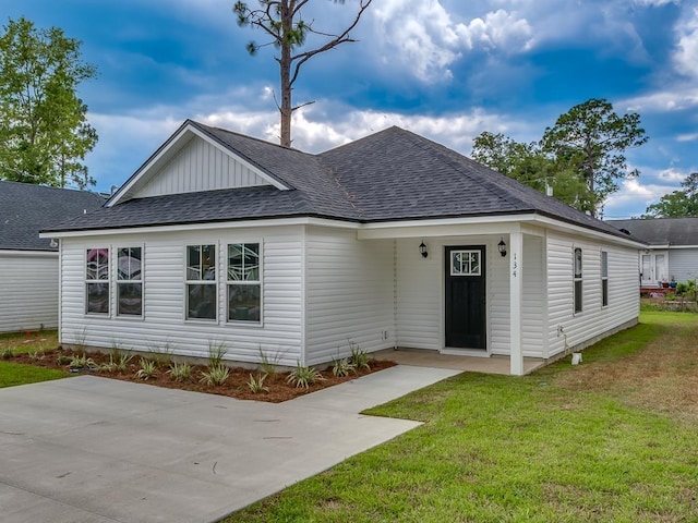 view of front of property with a front lawn and roof with shingles