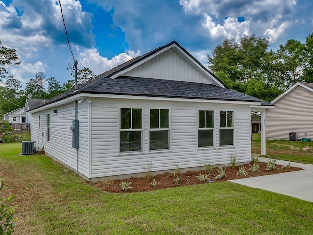 view of home's exterior with central AC, a lawn, and roof with shingles