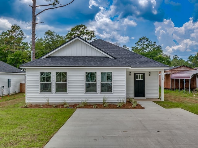 ranch-style home featuring roof with shingles and a front lawn